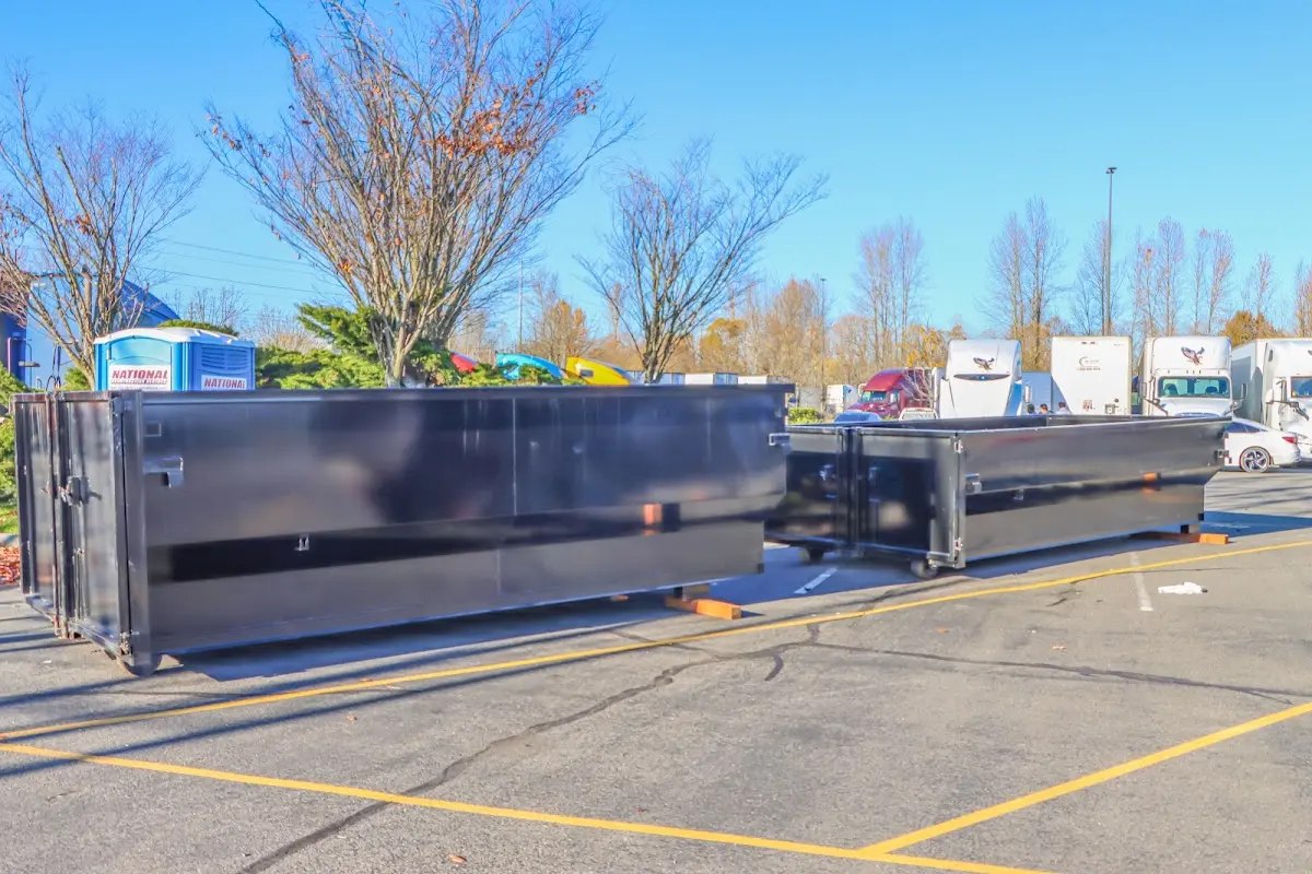 Professional dumpster rental service with roll-off container on residential driveway in Thompson